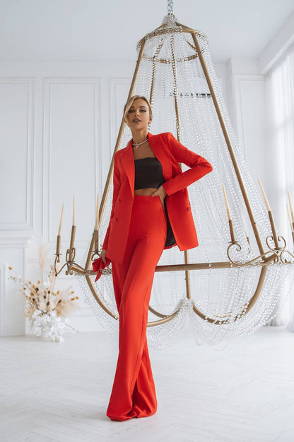 Woman in a red outfit standing in a stylish room with decorative elements.