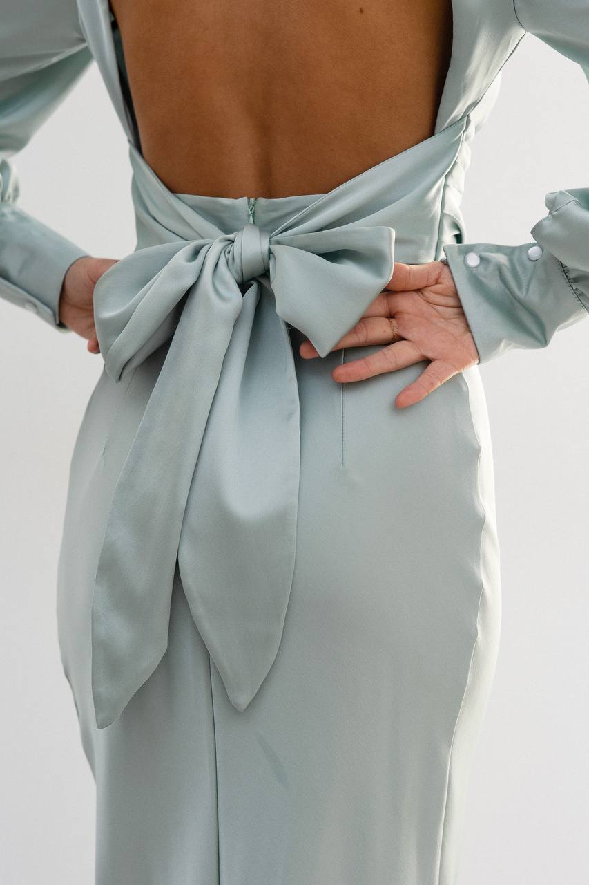 Light blue dress with a large bow detail on a white background