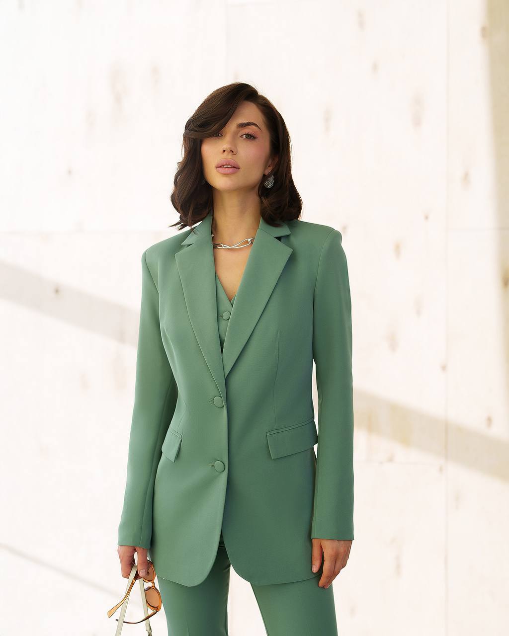 Woman wearing a green suit against a white background