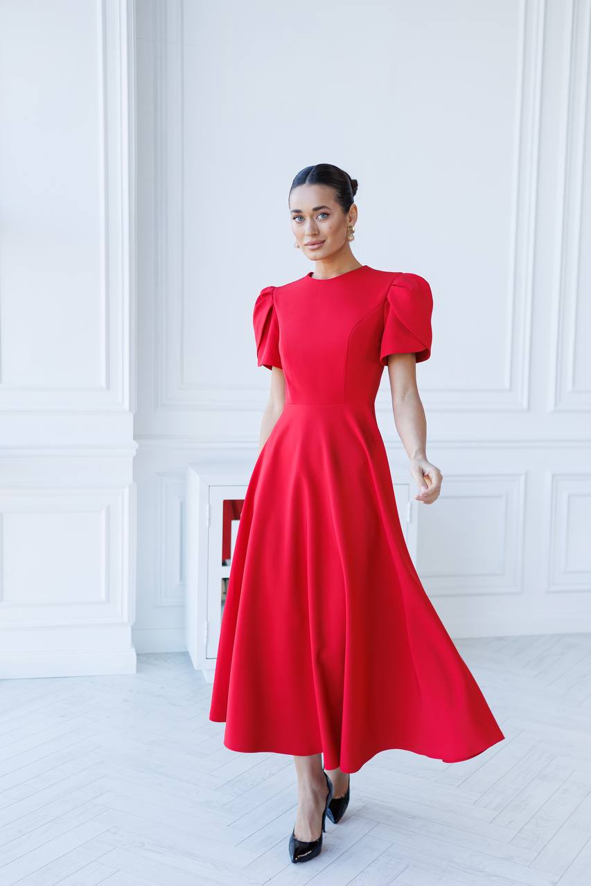 Woman wearing a red dress in a white room