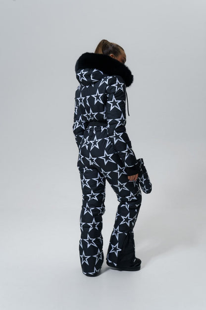 Person wearing a star-patterned onesie with fur-lined hood on a white background