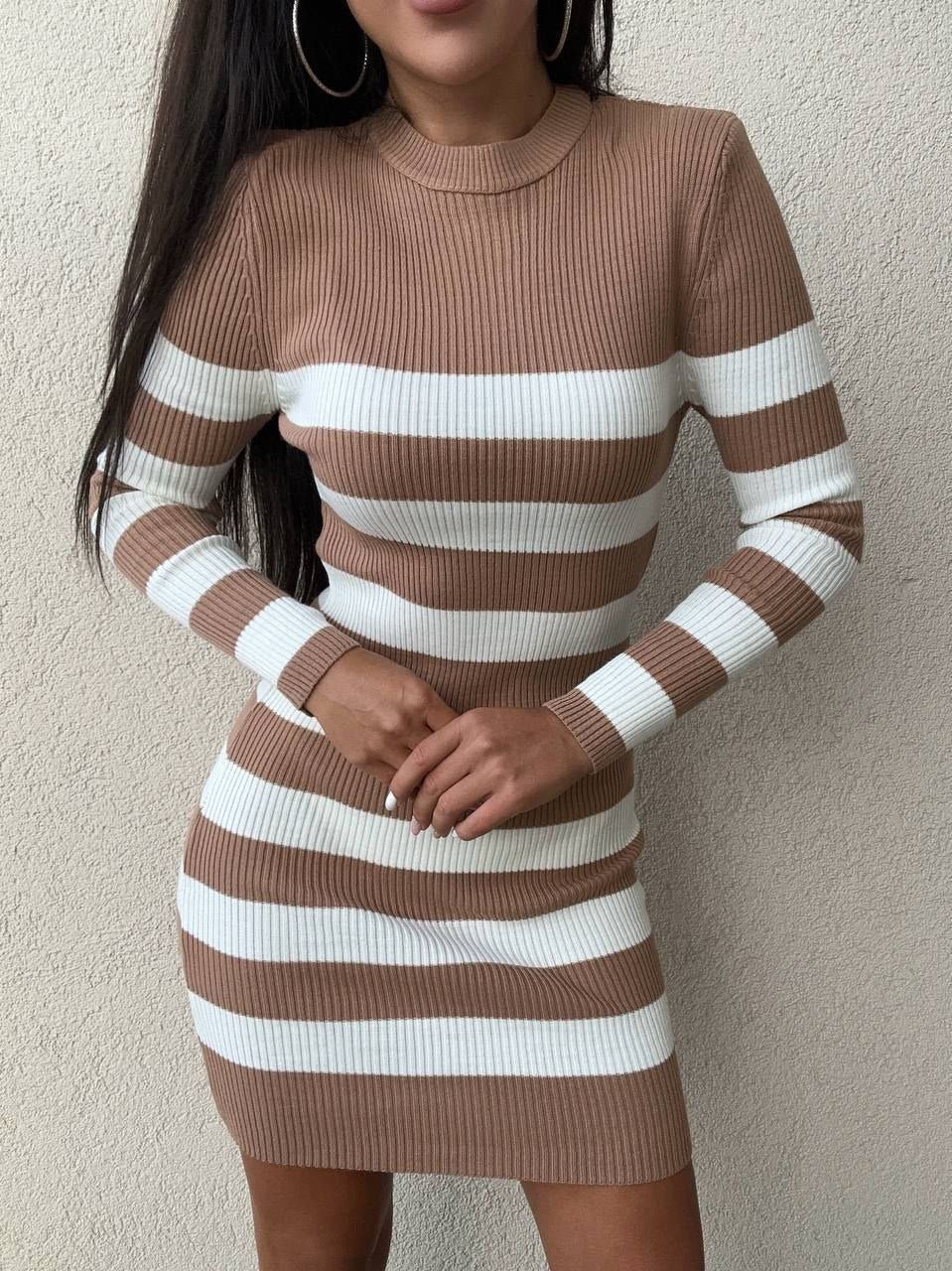 Brown and white striped dress worn by a person against a plain background
