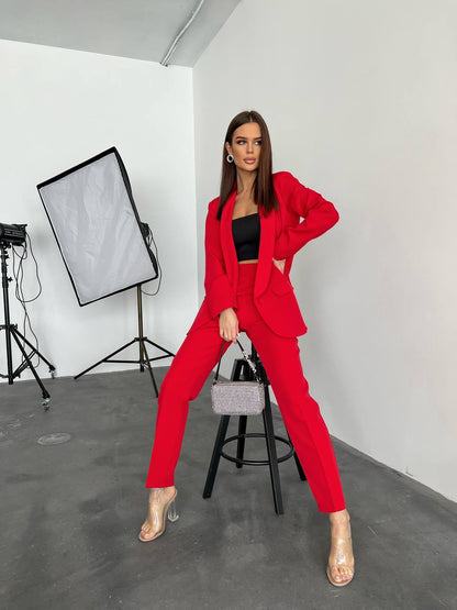 Woman in a red suit posing in a studio setting