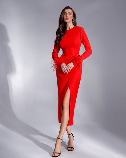 Woman wearing a red dress with a slit on a gray background