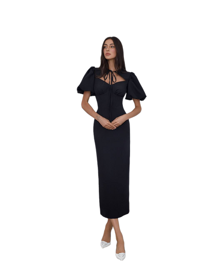 Woman wearing a black dress with puff sleeves on a white background