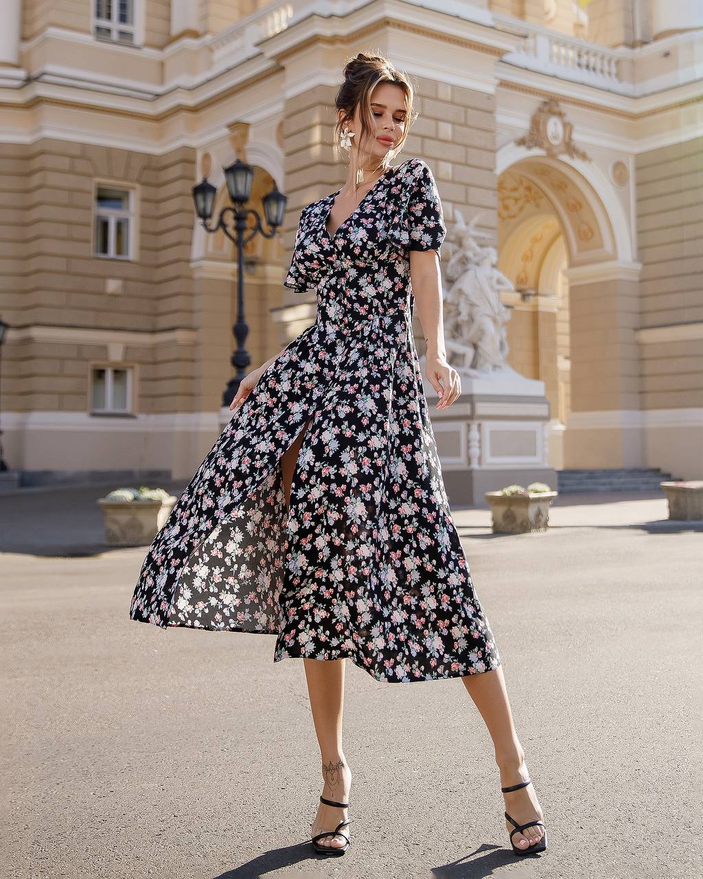 Woman in a floral dress standing in front of an elegant building