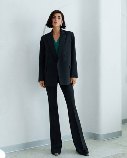 Woman wearing a black suit against a plain background