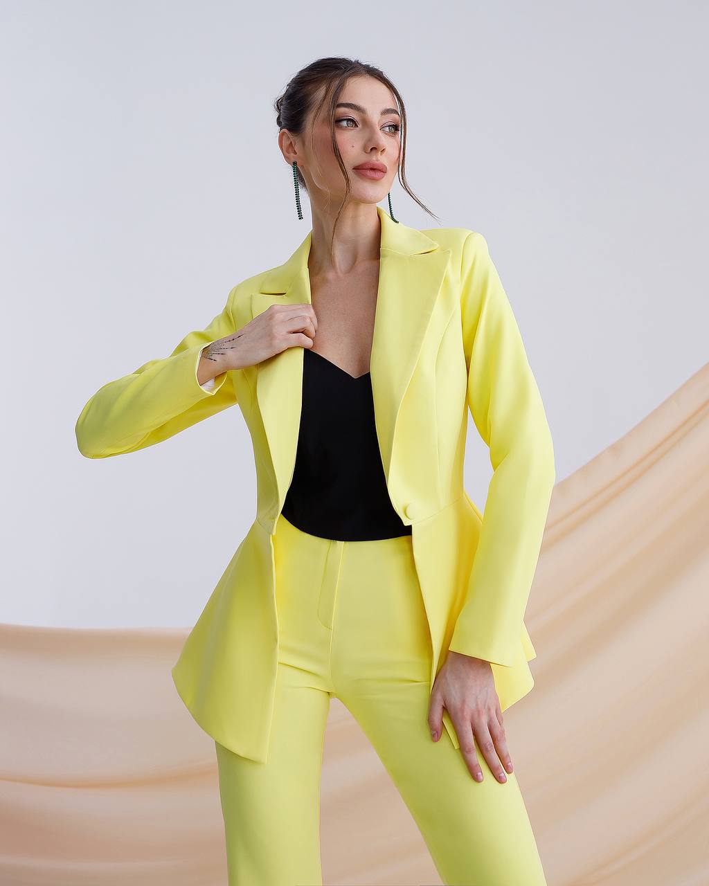 Woman wearing a bright yellow suit with a plain background