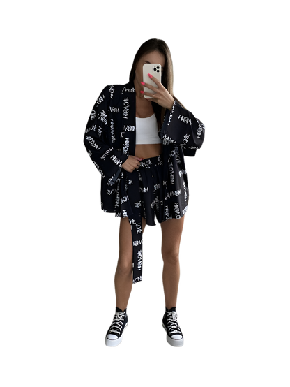 Person wearing a black and white patterned outfit with a white background
