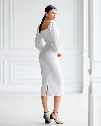 Woman wearing a white dress with a high slit in a minimalistic setting