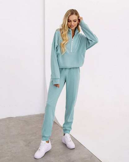 Woman wearing a light blue tracksuit against a white background