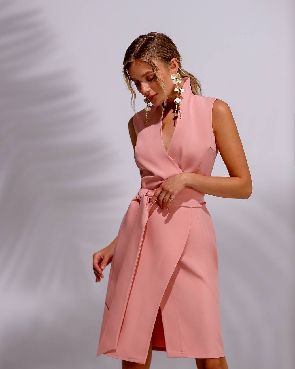 Woman wearing a pink dress against a plain background