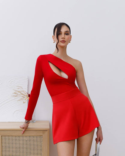 Woman wearing a red one-shoulder dress with a cutout design against a white background