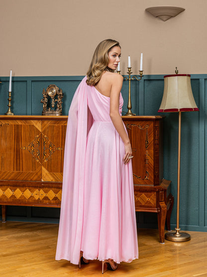 Woman in a pink dress standing in an elegant room with wooden furniture and decorative elements.