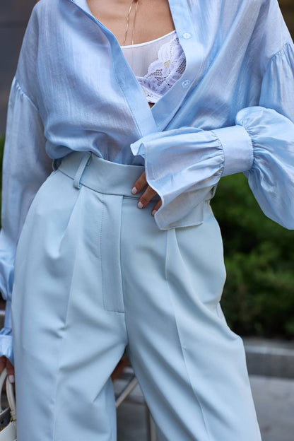 Person wearing a light blue outfit with a blurred background