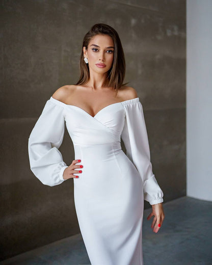 Woman wearing a white off-shoulder dress against a neutral background