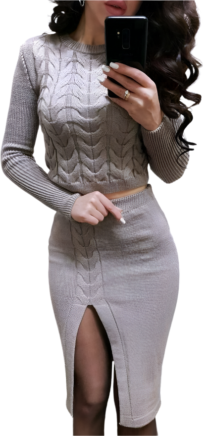Woman wearing a gray cable knit sweater and skirt set, holding a phone.