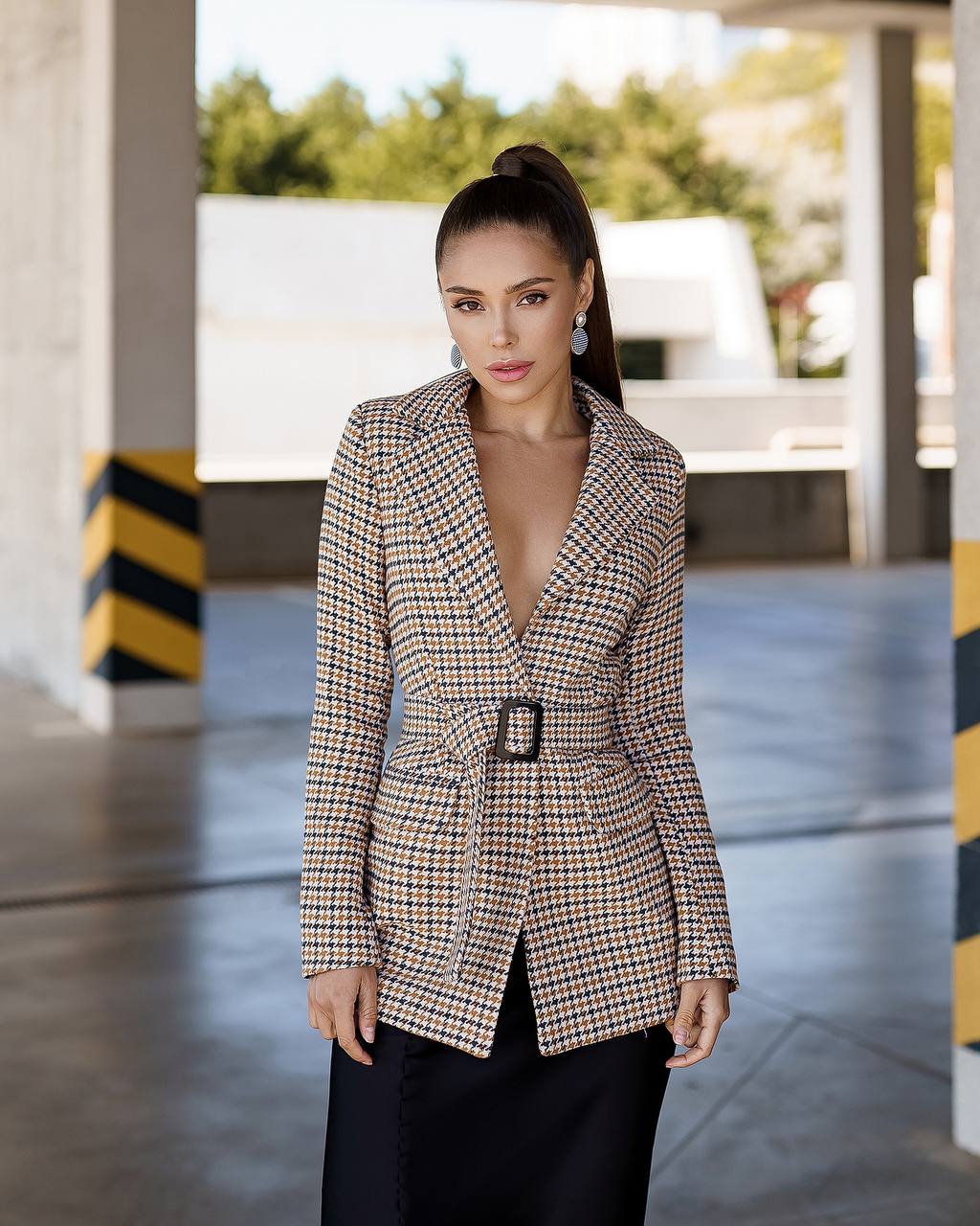 Woman wearing a checkered blazer in an outdoor setting