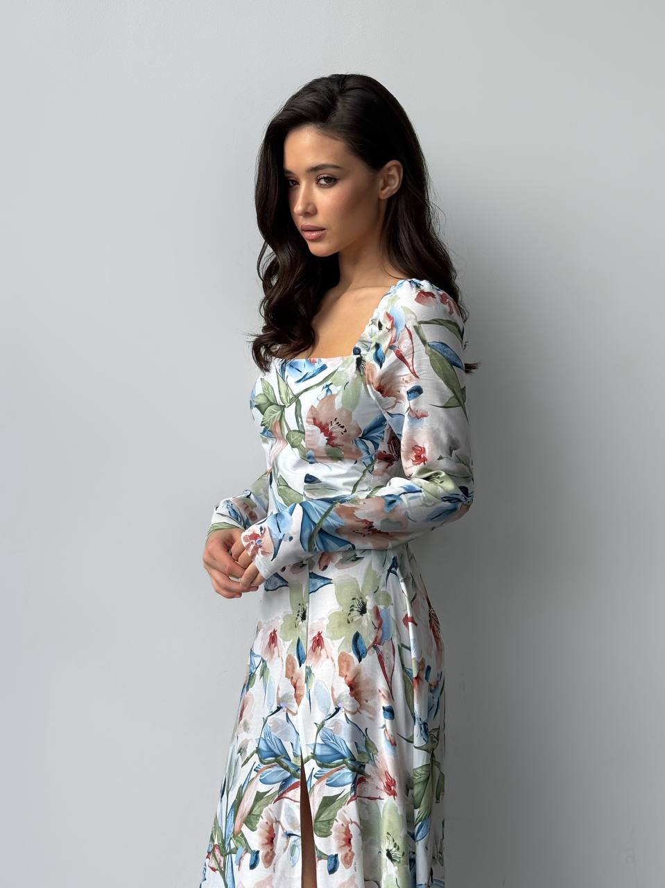 Woman wearing a floral dress against a plain background