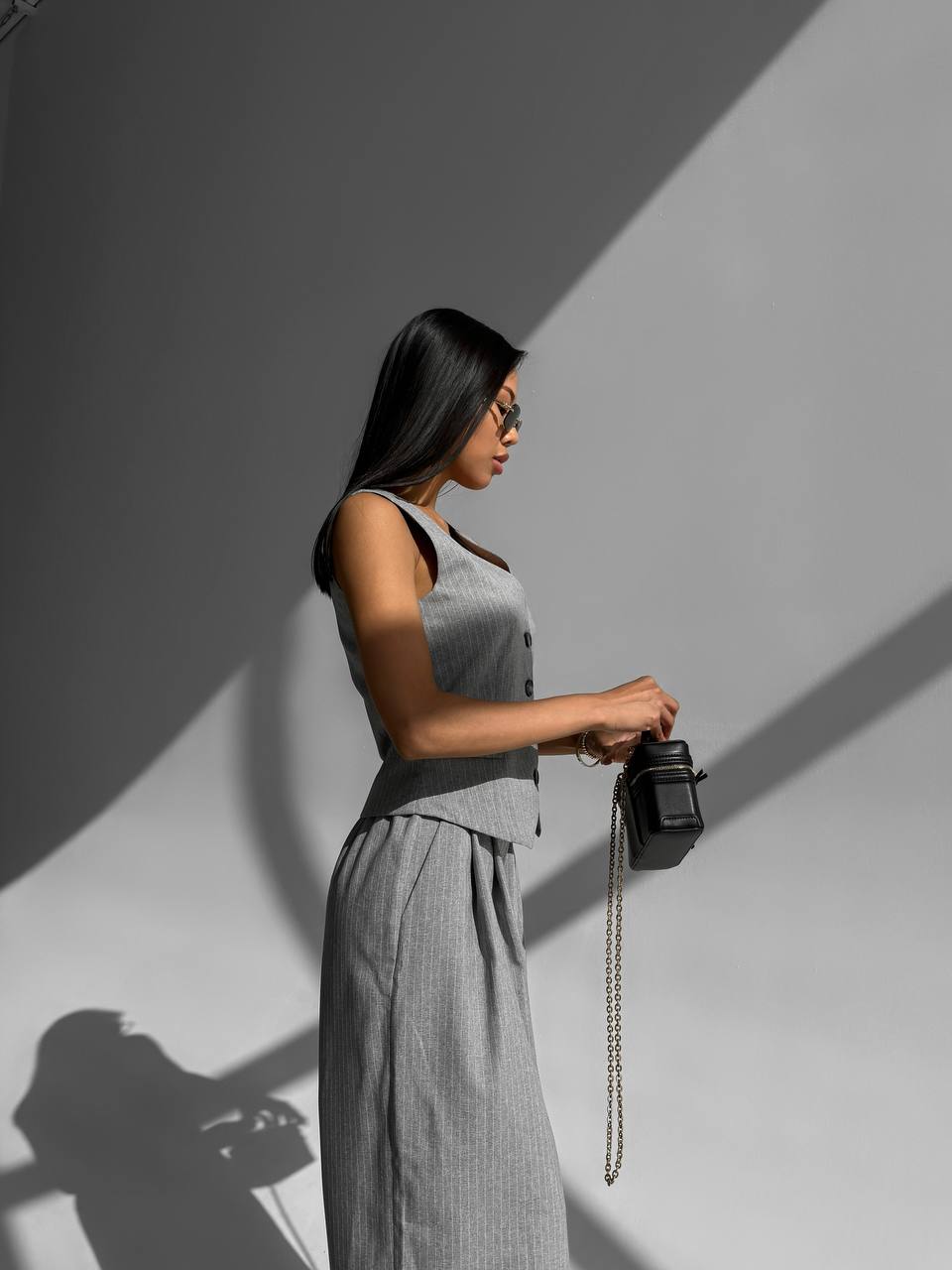 Woman holding a camera against a gray background