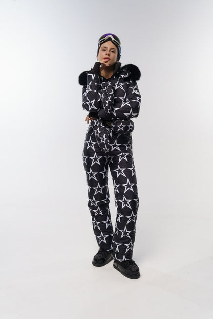 Person wearing a black and white star-patterned onesie with a matching hat on a white background