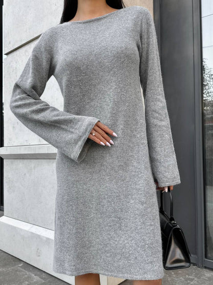 Person wearing a gray dress with long sleeves in an urban setting