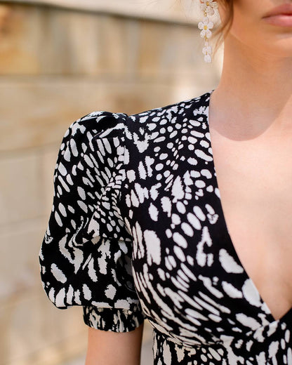 Black and white patterned dress with puff sleeves worn by a person.