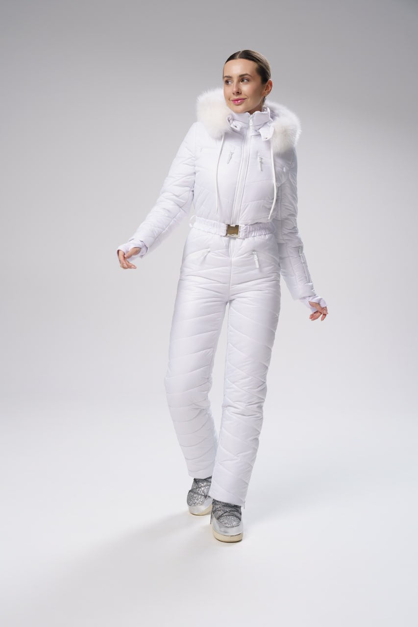 Person wearing a white puffer suit with fur trim on a gray background