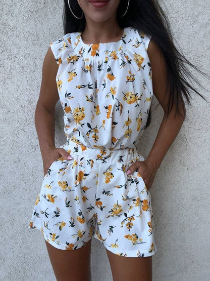 Woman wearing a white floral romper against a plain background