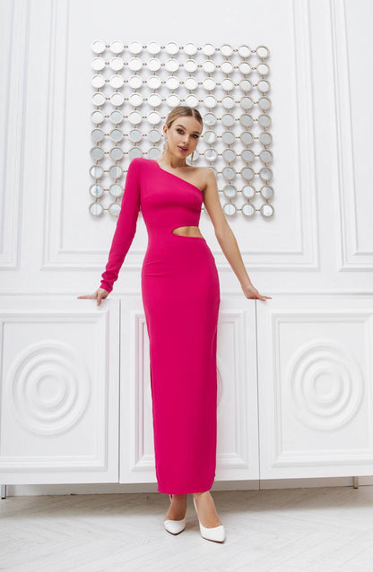 Woman wearing a pink one-shoulder dress against a white wall with decorative patterns.