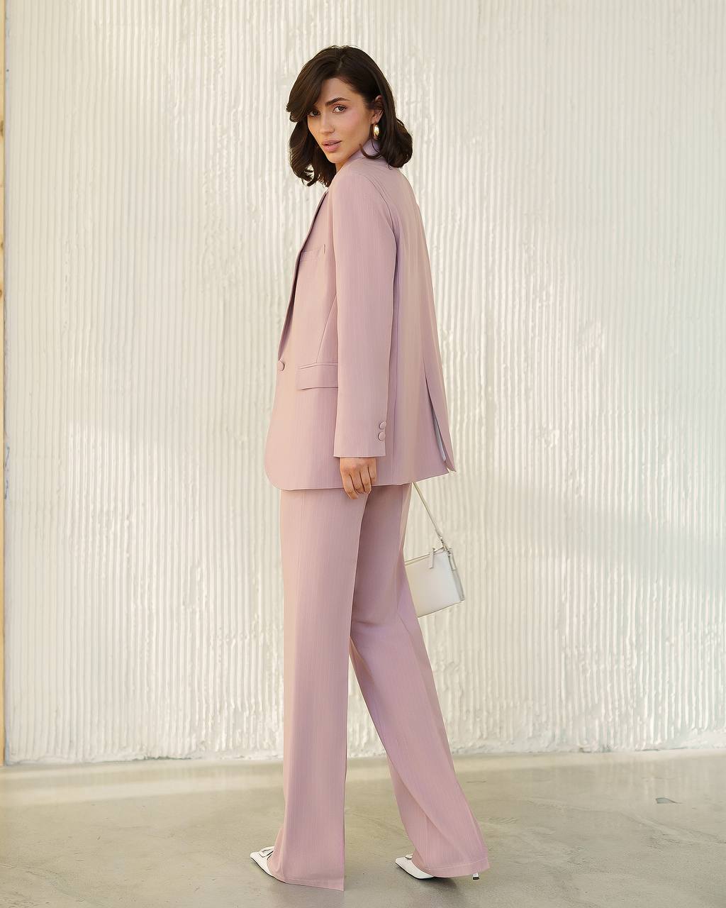 Woman wearing a pink suit with a white background