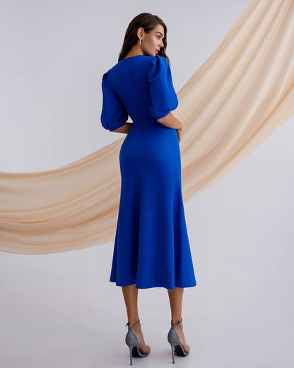 Woman wearing a blue dress with a plain background