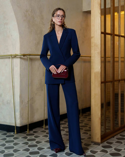 Woman in a blue suit standing in an elegant interior setting