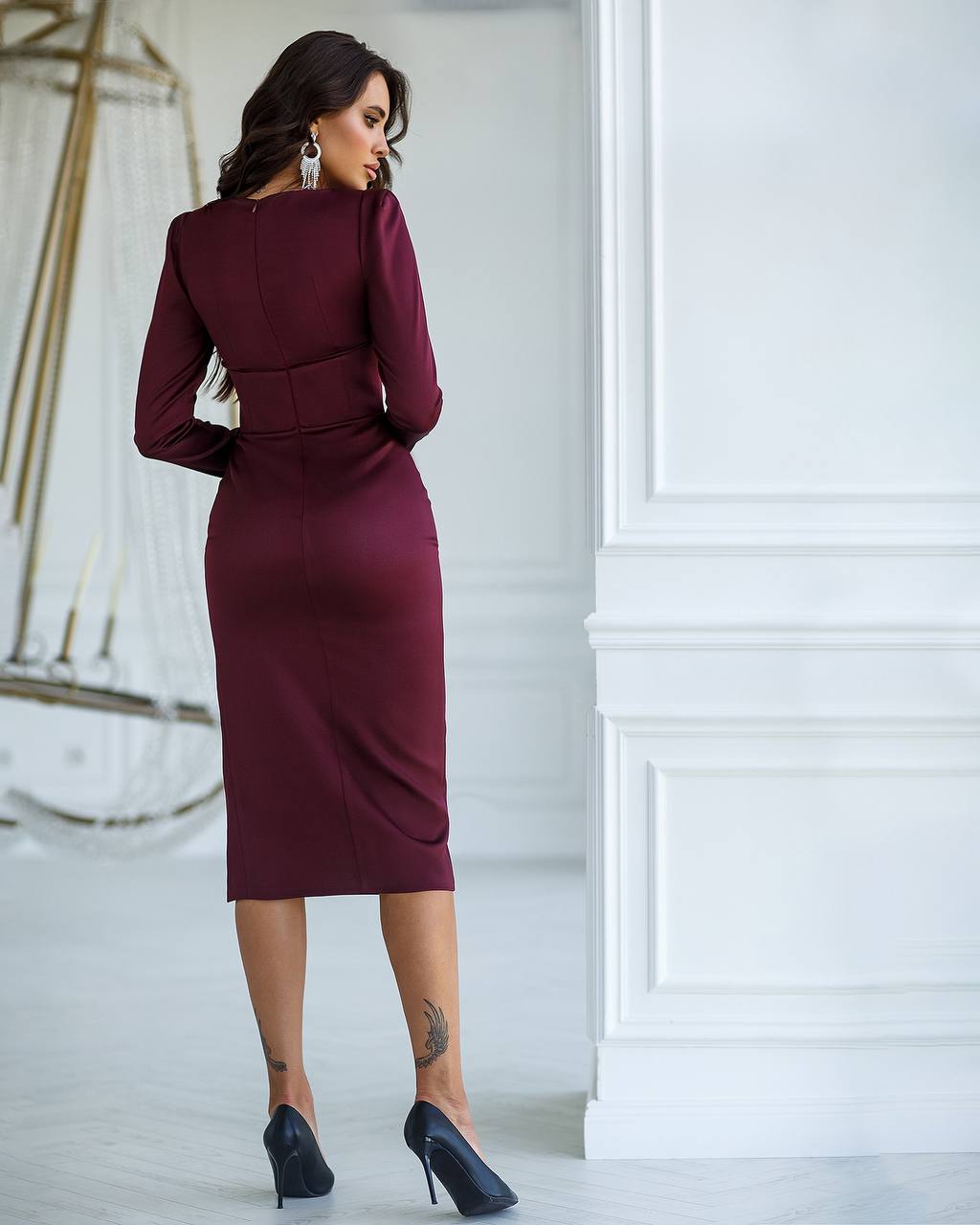 Woman wearing a burgundy dress in a white room