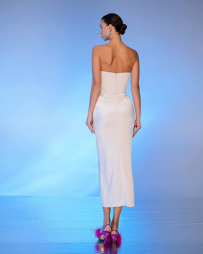 Woman wearing a strapless white dress on a blue gradient background