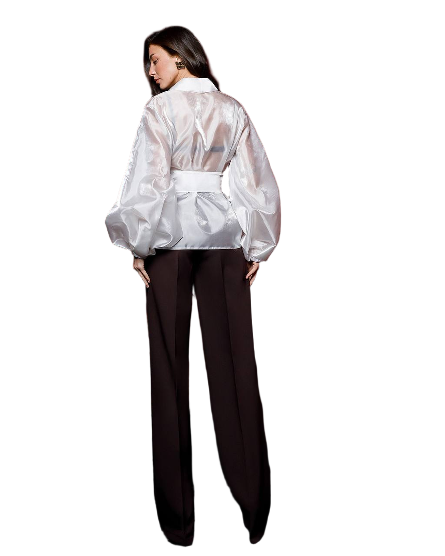 Person wearing a sheer white blouse over a black outfit on a white background