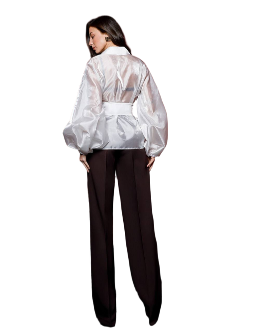 Person wearing a sheer white blouse over a black outfit on a white background