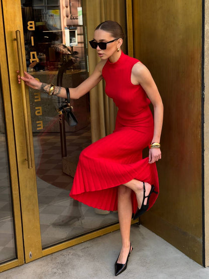 Woman in a red dress standing next to a gold door