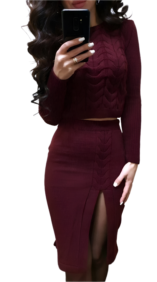 Person wearing a burgundy long-sleeve top and skirt set, holding a phone.
