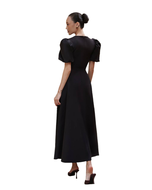 Woman wearing a black dress with puff sleeves on a white background