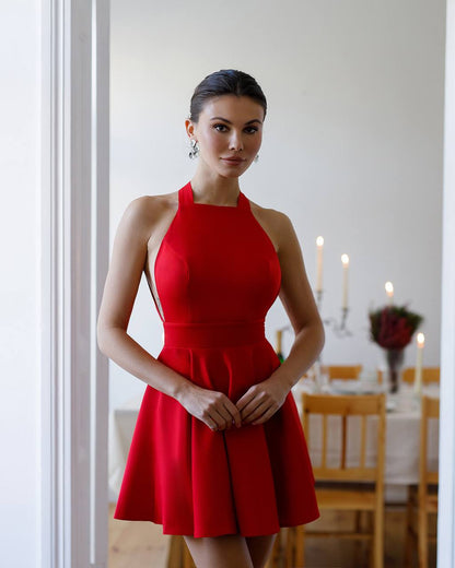 Woman in a red dress standing in a dining room setting