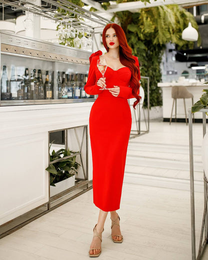 Woman in a red dress holding a glass in a modern indoor setting