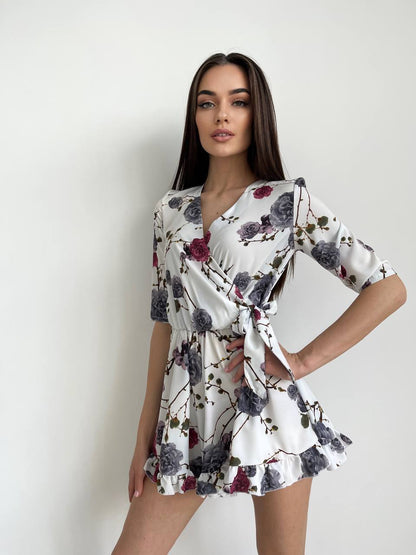Woman wearing a floral dress against a plain background
