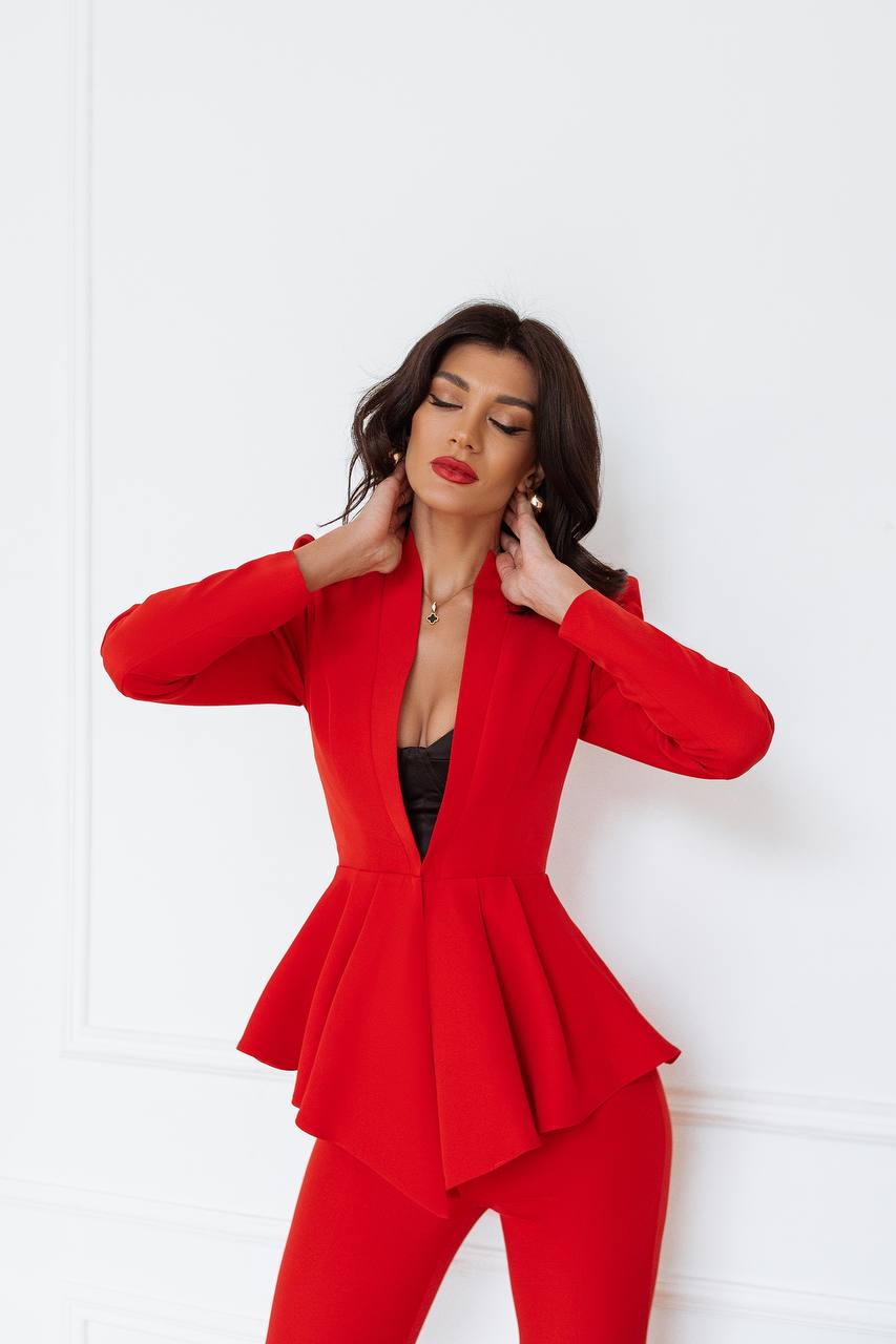 Woman wearing a red suit against a white background