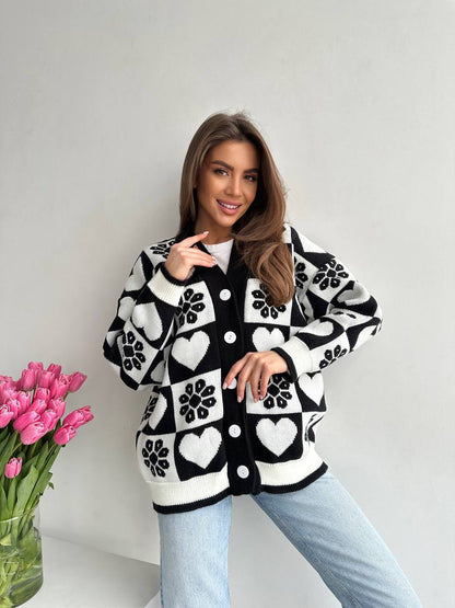 Woman wearing a black and white patterned cardigan with pink tulips on a white background