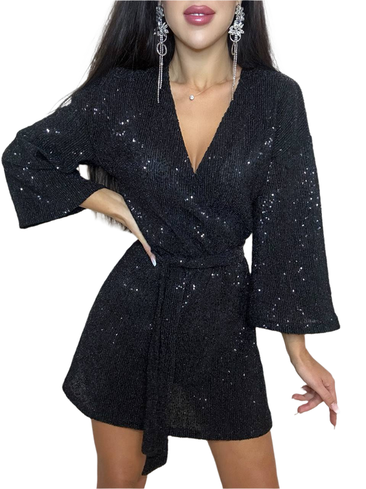 Black sequin dress worn by a model on a white background