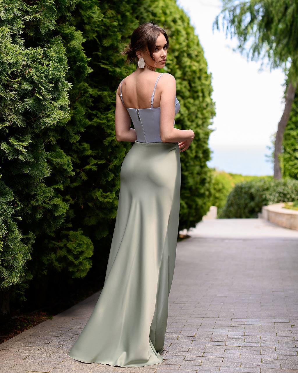 Woman in a two-tone dress standing in a garden setting