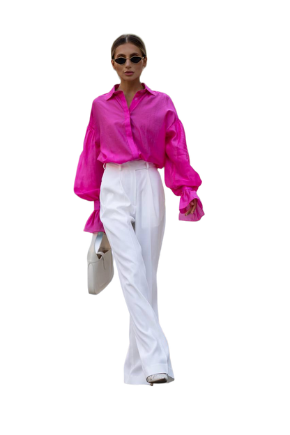 Woman wearing a bright pink shirt and white pants on a white background