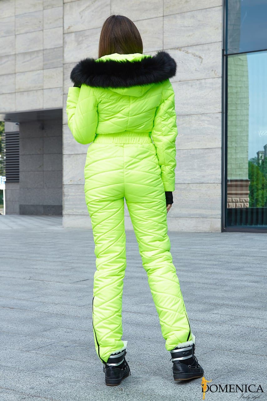 Person wearing a bright green puffer suit with black fur hood in an urban setting.