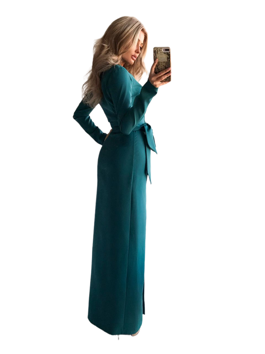 Woman wearing a teal long-sleeve dress with a belt, taking a selfie on a white background.